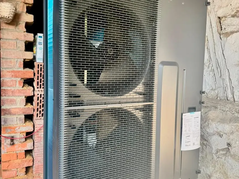 Außeneinheit einer Wärmepumpe an einer gemauerten Fassade